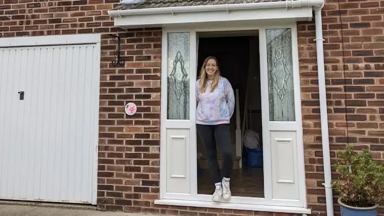Beth standing at a front door